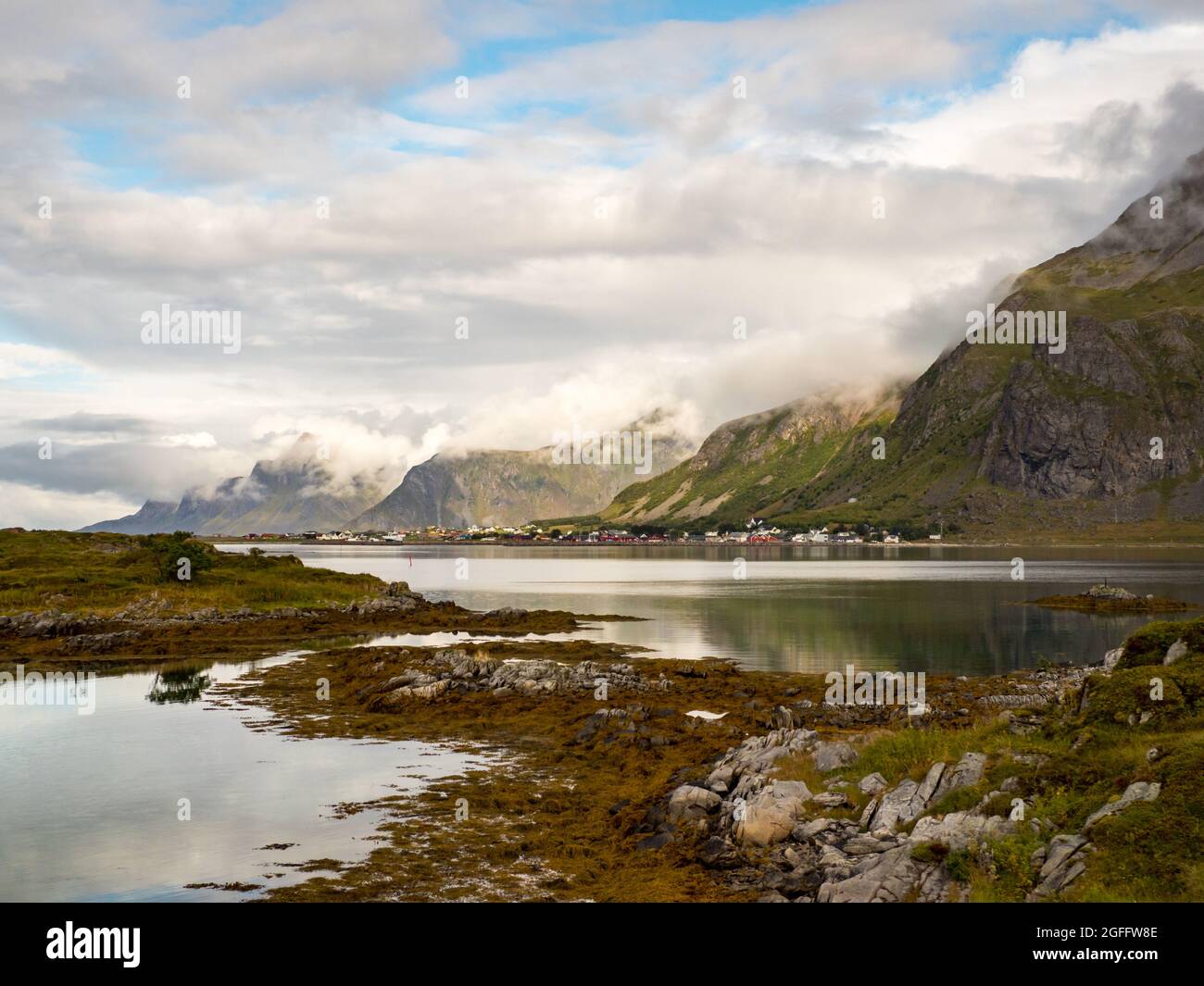 Fantastische Aussicht auf die Berge, die aus dem Meer hervorgehen, bedeckt mit einer Wolkendecke. Lofoten-Inseln, Flakstadøya-Insel, Nordnorwegen Stockfoto