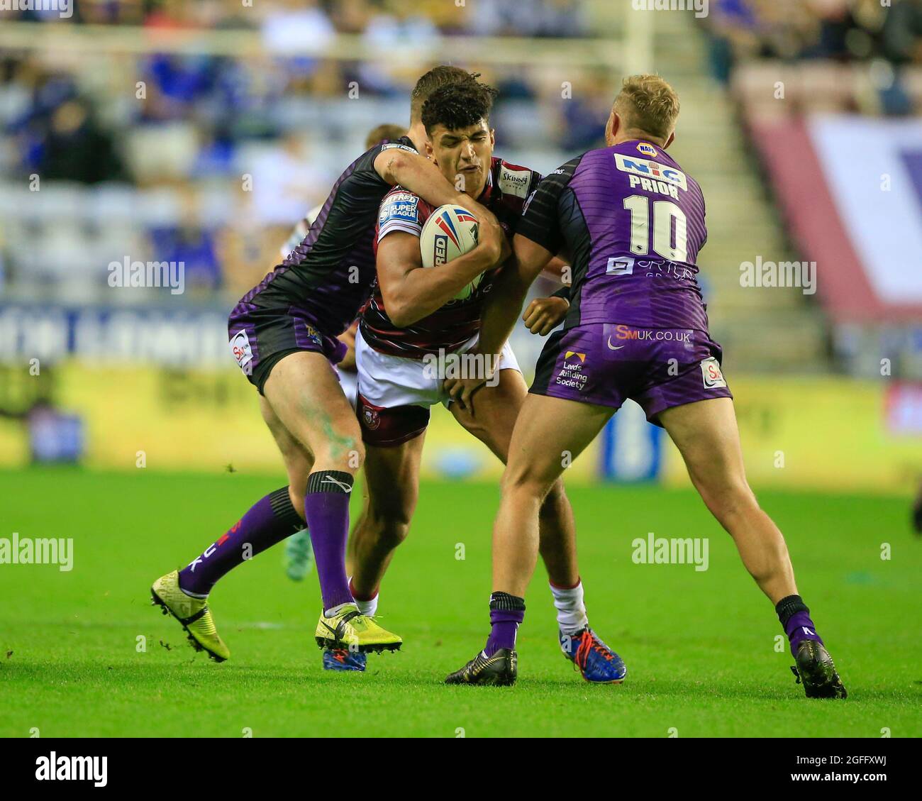 Wigan, Großbritannien. August 2021. Kai Pearce-Paul (27) von Wigan Warriors wird von Matt Prior (10) von Leeds Rhinos in Wigan, Vereinigtes Königreich am 8/25/2021 gestoppt. (Foto von Conor Molloy/News Images/Sipa USA) Quelle: SIPA USA/Alamy Live News Stockfoto