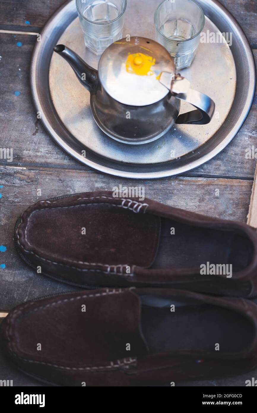 Marokkanischer Teekocher mit Gläsern und Schuhen Stockfoto