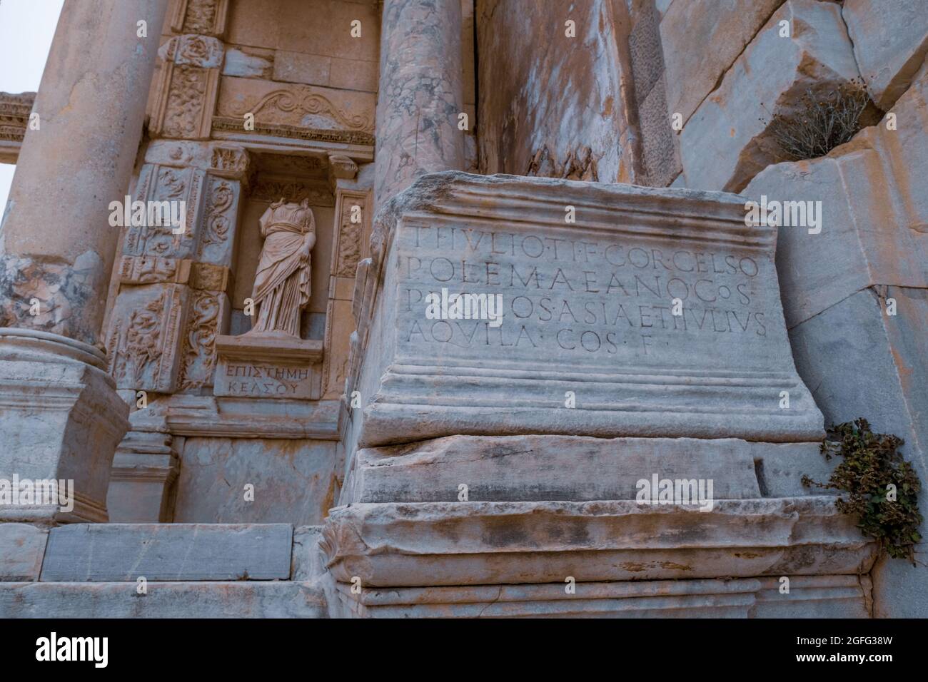 Selcuk, Izmir, Türkei - 03.09.2021: Altgriechischer Text an der Wand der Celsus Bibliothek und Statuen in Ephesus Ruinen, historische antike römische archäologische Stockfoto