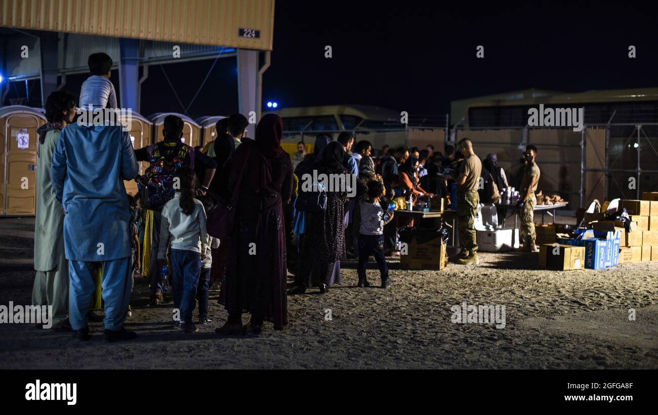 Afghanische Evakuierte stehen vor dem Passagierterminal in einer Schlange, um in die Busse des Ali Al Salem Air Base, Kuwait, 24. August 2021 zu steigen. Das Verteidigungsministerium hat sich verpflichtet, die Evakuierung amerikanischer Bürger, Visa für Sondereinwanderer und anderer gefährdete Personen aus Afghanistan zu unterstützen. (USA Foto der Luftwaffe von Staff Sgt. Ryan Brooks) Stockfoto