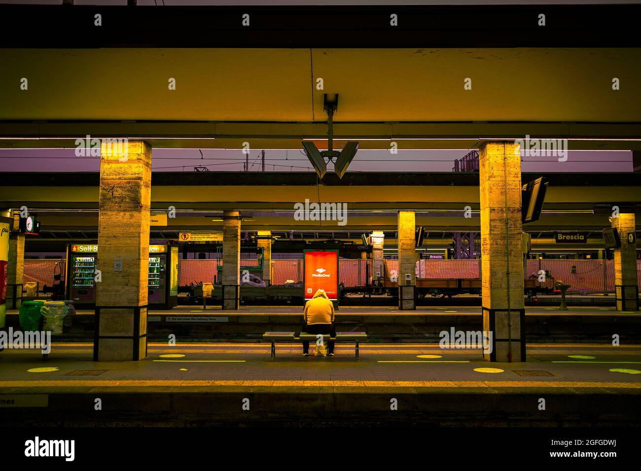 Eine Aufnahme, die ich in einem der italienischen Bahnhöfe brescia aufgenommen habe, filmisch als wäre es ein Film, zeigt Einsamkeit auf einer langen Reise, ig>egnubis Stockfoto