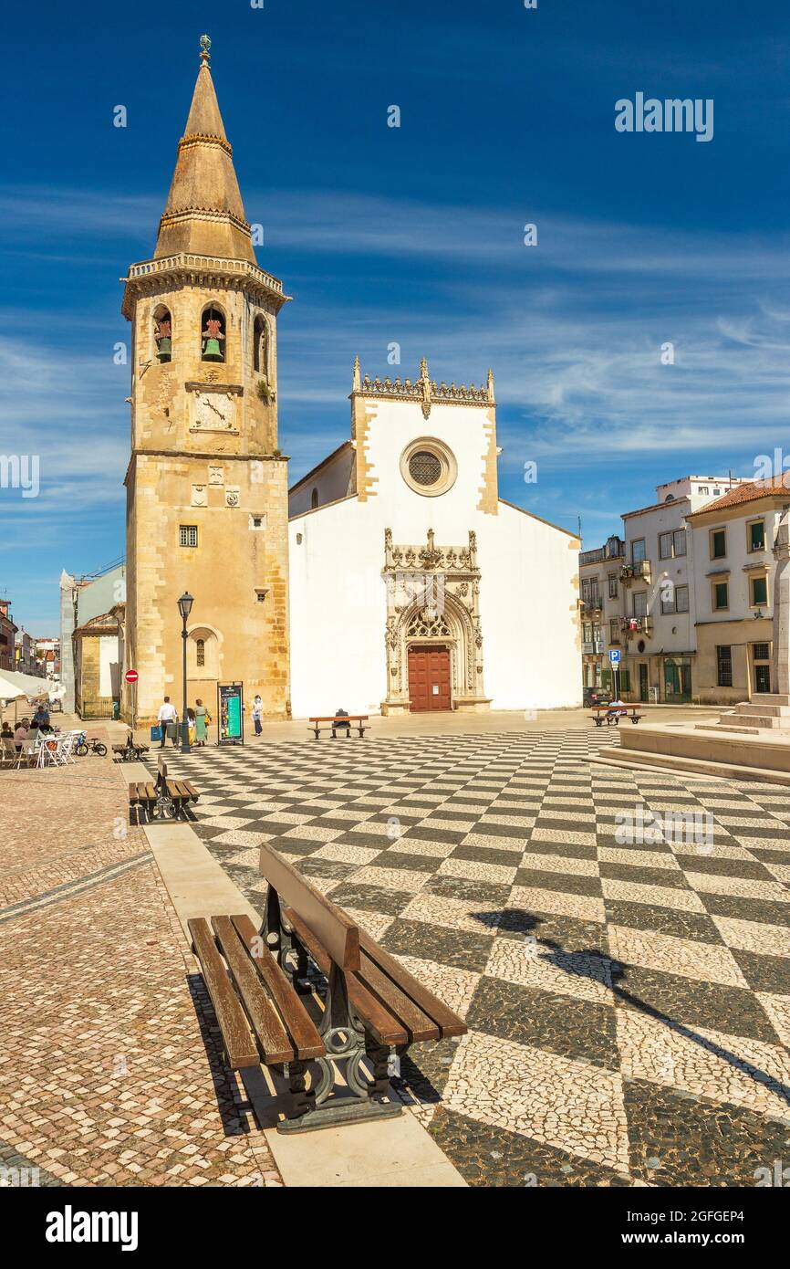 Tomar, Portugal - 3. Juni 2021: Kirche von São João Baptista in Tomar, Portugal, von der Praça da República aus gesehen, mit Bänken im Vordergrund. Stockfoto