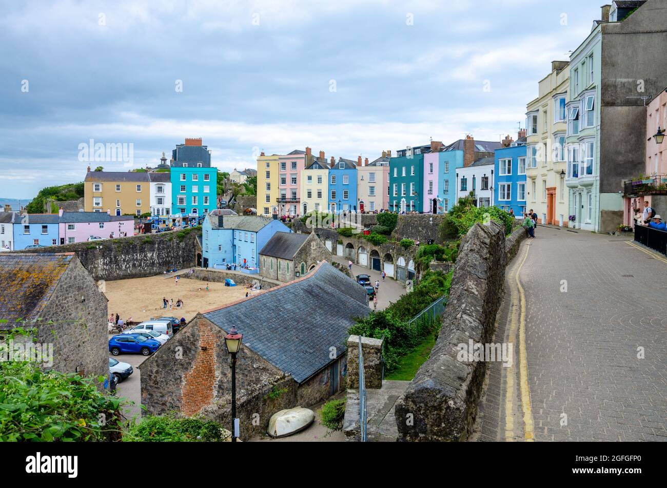 Ein Blick auf die Crackwell Street mit bunten Häusern und den Hafen unten in Tenby in Pembrokeshire, Wales. Stockfoto