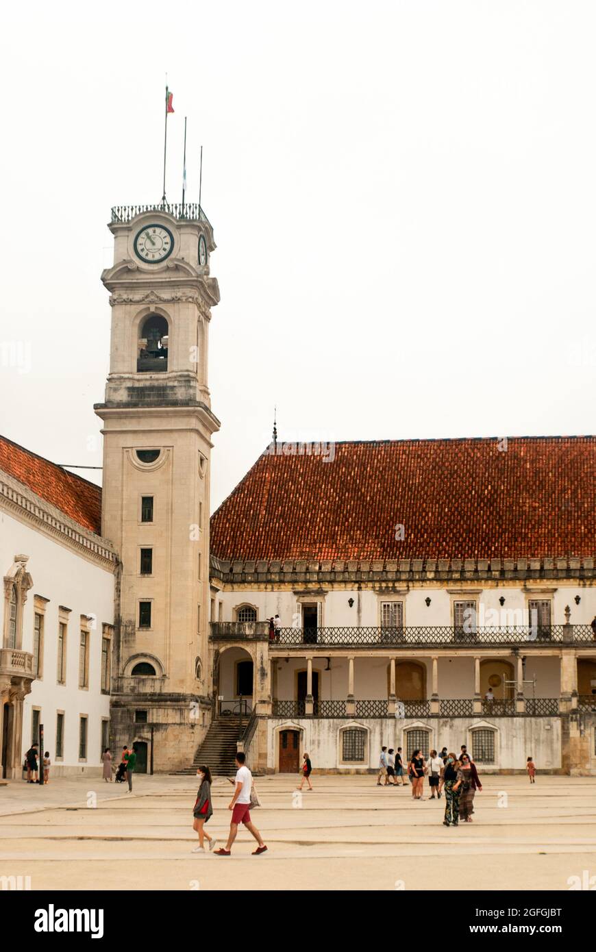 Turm der Universität Coimbra und die Touristen, die um den Platz herum spazieren, trüber Morgen - Portugal, Vertikal, August 2021 Stockfoto