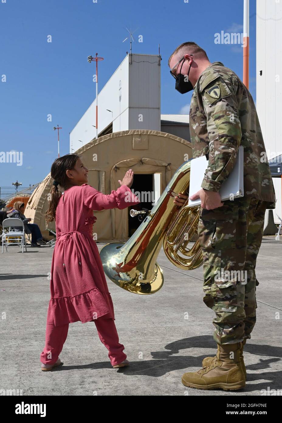 US Army Staff Sgt. William Karsten, Mitglied der U.S. Army Europe and Africa Band and Chorus, spricht während der Operation Allies Refuge auf dem Ramstein Air Base, Deutschland, am 22. August 2021 mit einem afghanischen Kind. Die U.S. Army Europe Band & Chorus ist in der Sembach Kaserne stationiert und ist derzeit der führende musikalische Botschafter der Armee in Europa. (USA Luftwaffe Foto von Senior Airman Caleb S. Kimmell) Stockfoto