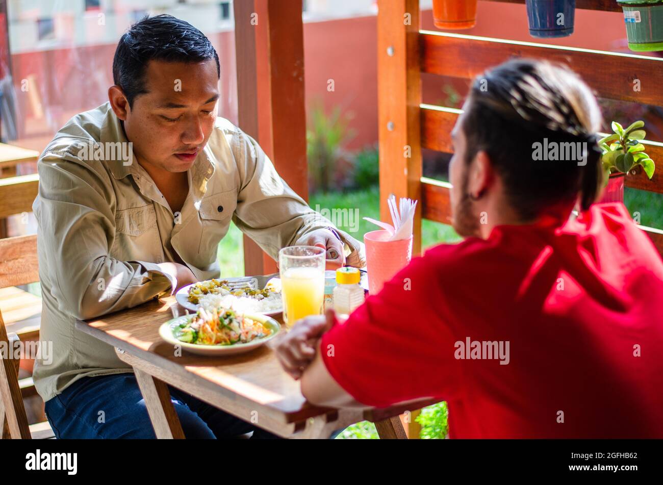 Gut aussehende junge Menschen zur Festsetzung der Tabelle mit Servietten, bevor die Gäste kommen Stockfoto