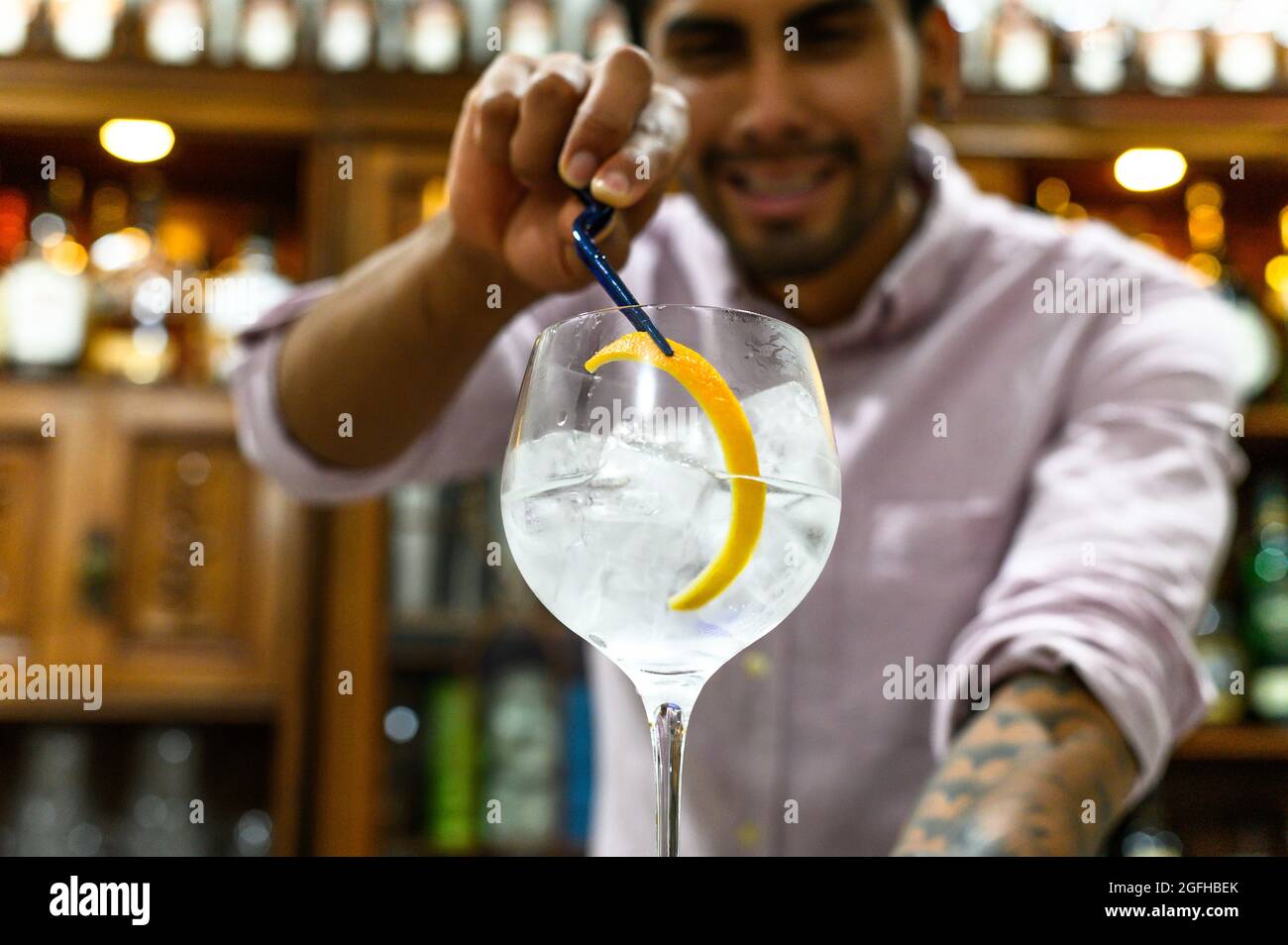 Der Barkeeper schmückt ein Glas frischen alkoholischen Cocktails an der Theke, Nahaufnahme Stockfoto