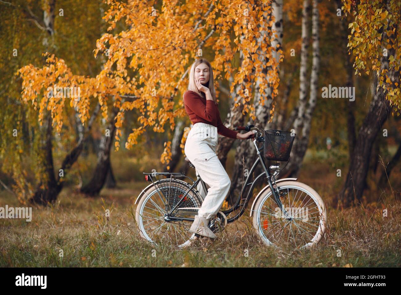 Glücklich aktive junge Frau Fahrrad im Herbst Park reiten. Stockfoto