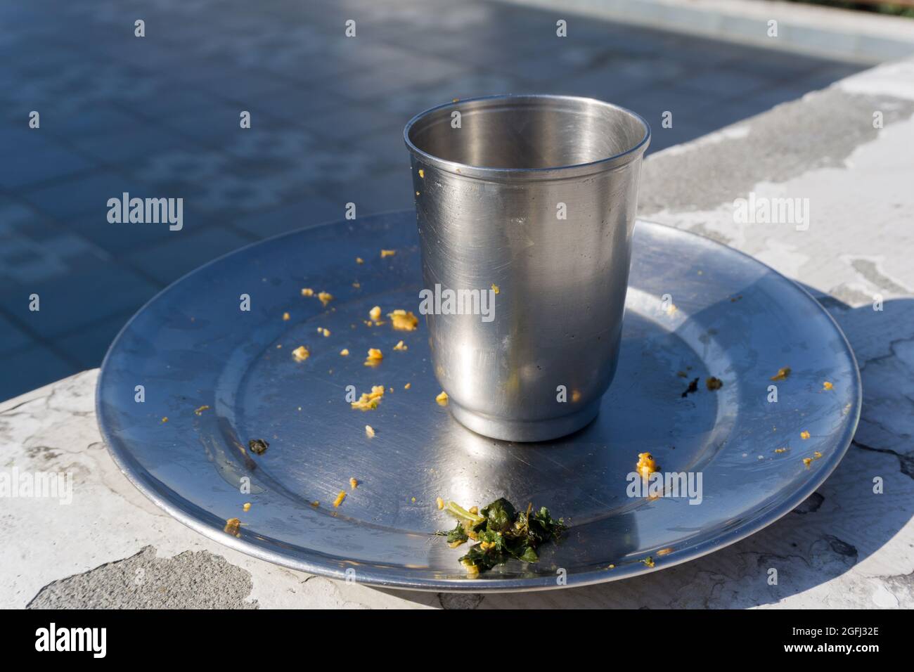 Ein leeres Stahlglas und eine Platte nach dem Essen. Stockfoto