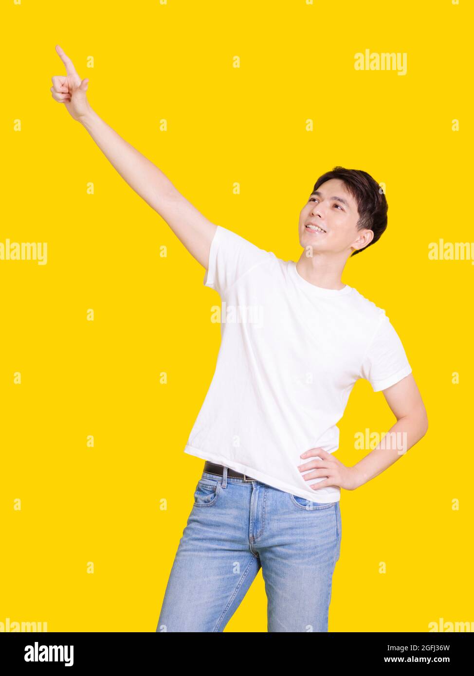 Fröhlich hübscher, lächelnder junger Mann mit auftreffenden Händen. Isoliert auf gelbem Hintergrund. Stockfoto