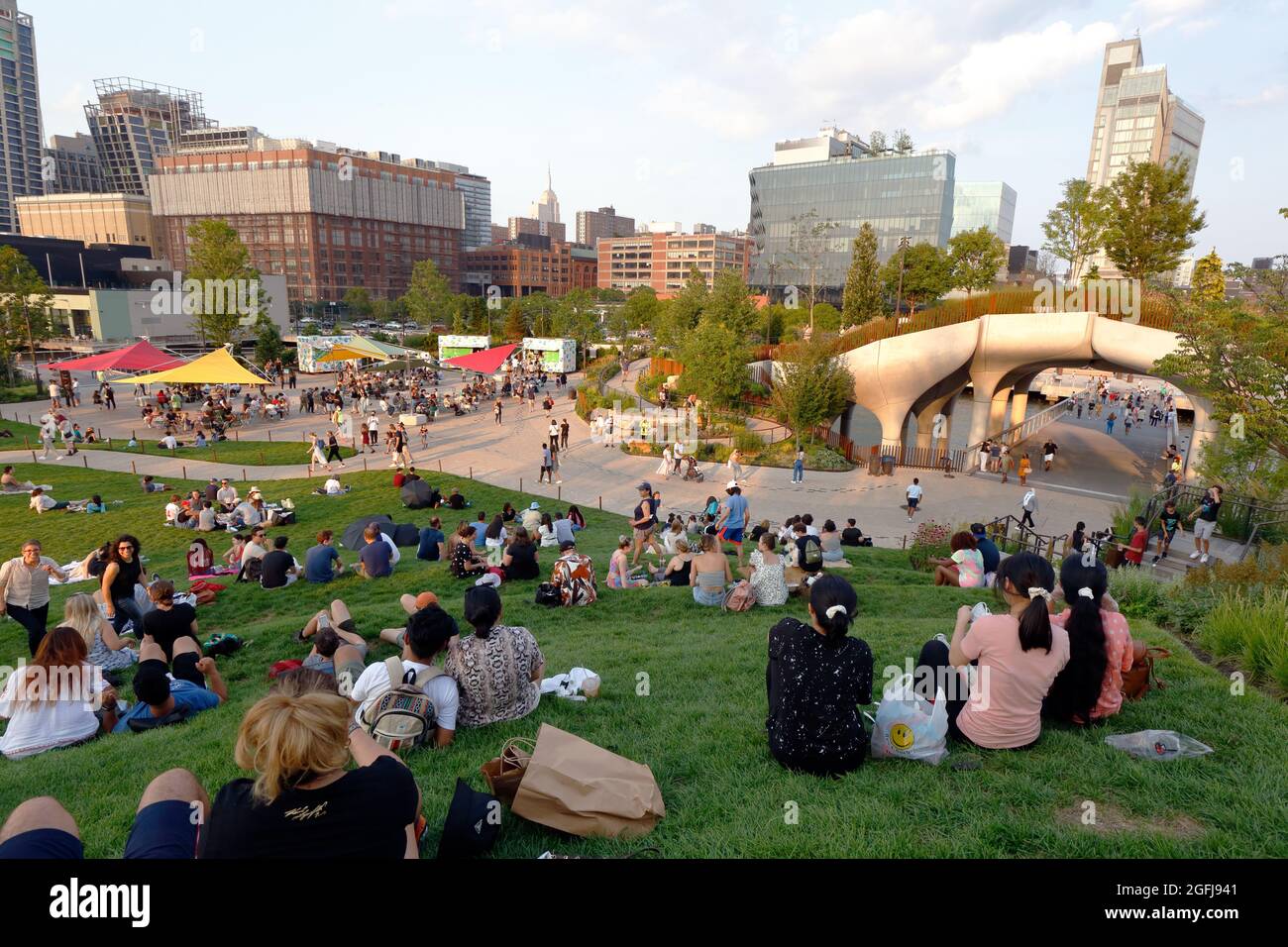 Menschen, die an bestimmten Tagen auf dem Rasen faulenzen, dürfen die Besucher auf dem Rasen am Little Island @ Pier 55 im Hudson River Park, New York, NY, genießen. Stockfoto