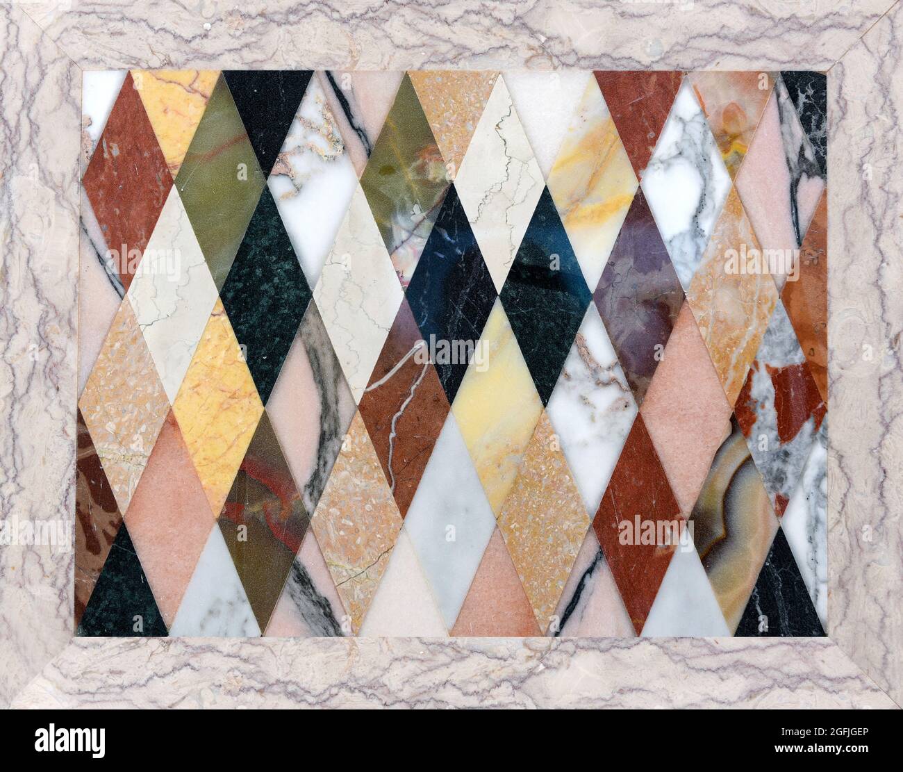 Buntes Mosaik aus verschiedenen Arten von italienischem Marmor in einem wiederholten geometrischen Muster aus Diamanten, das die Texturen der Steine zeigt Stockfoto