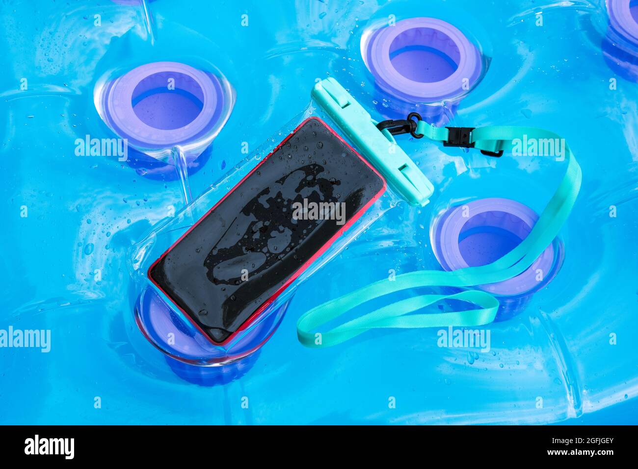 Das Mobiltelefon ist in einem durchsichtigen, wasserdichten Kunststoffgehäuse zum Schutz vor Wasser und Feuchtigkeit im Sommer eingefasst, während Sie Wassersport im Freien treiben Stockfoto