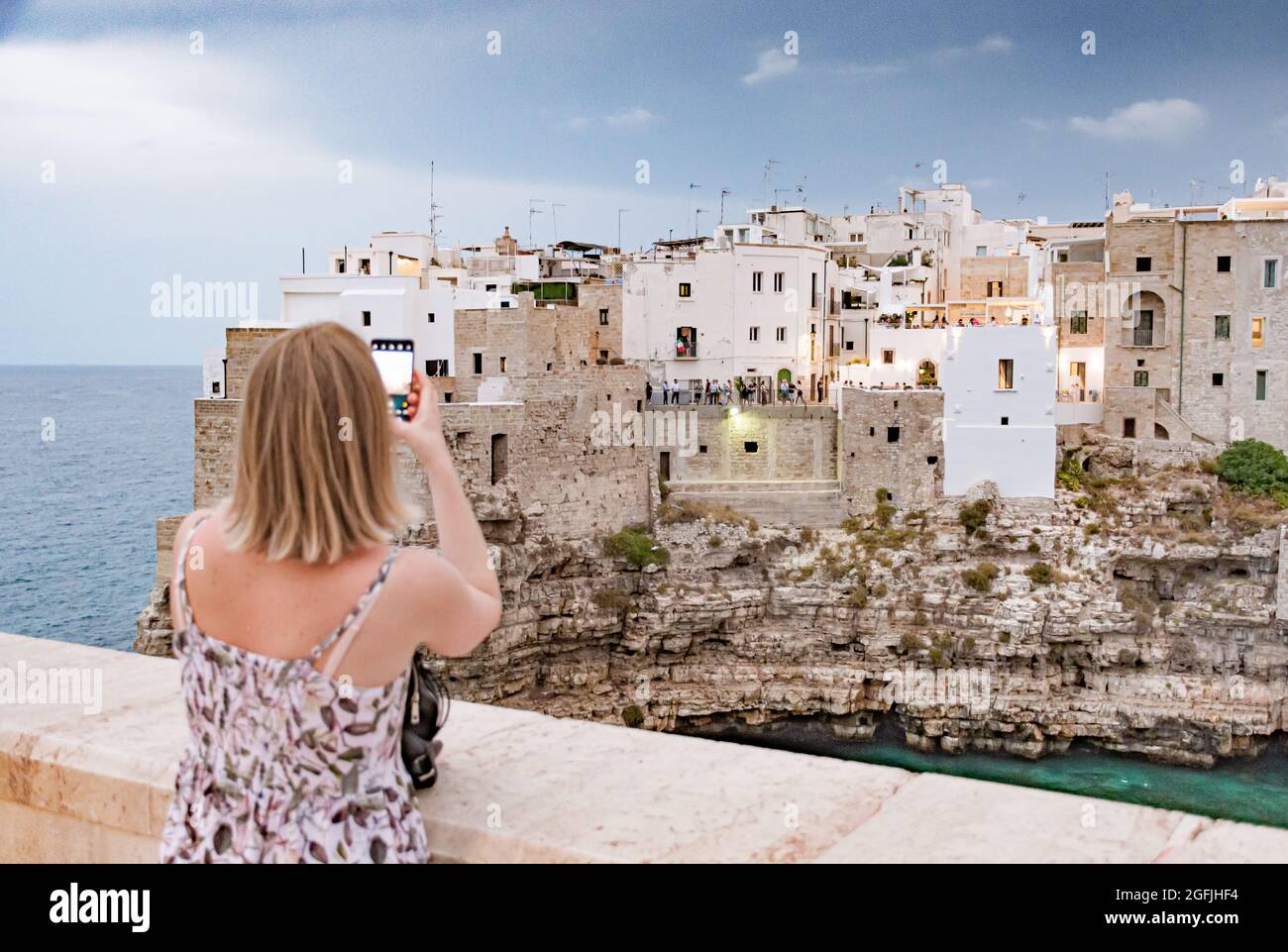 Polignano a Mare. Stadt auf den Klippen, Region Apulien, Italien, Europa. Blonde Haare Tourist Mädchen fotografieren Stockfoto