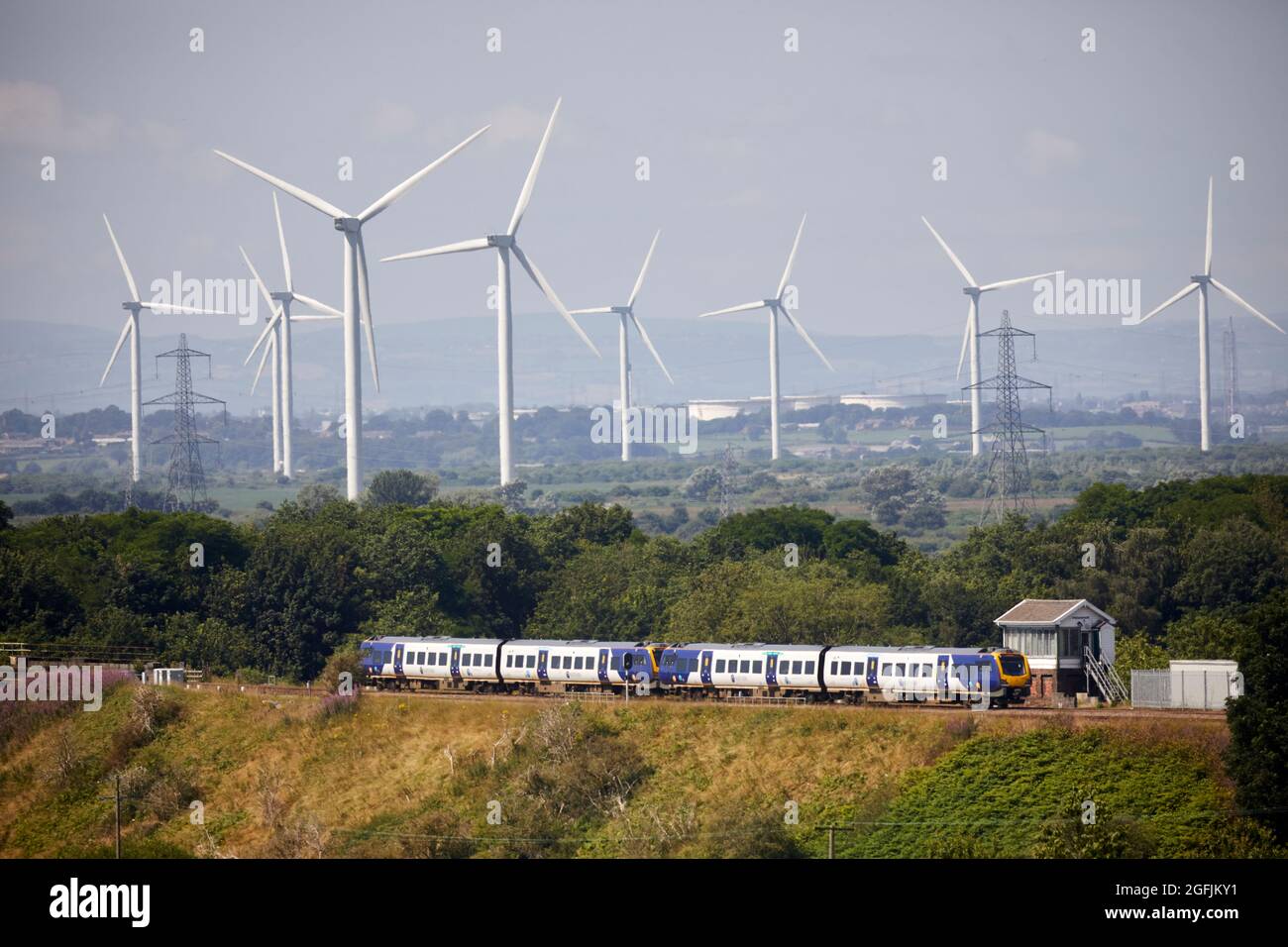 Der Zug überquert den Weaver Viadukt in Frodsham, cheshire. Und Frodsham Wind Farm große Onshore-Kraftwerke Stockfoto