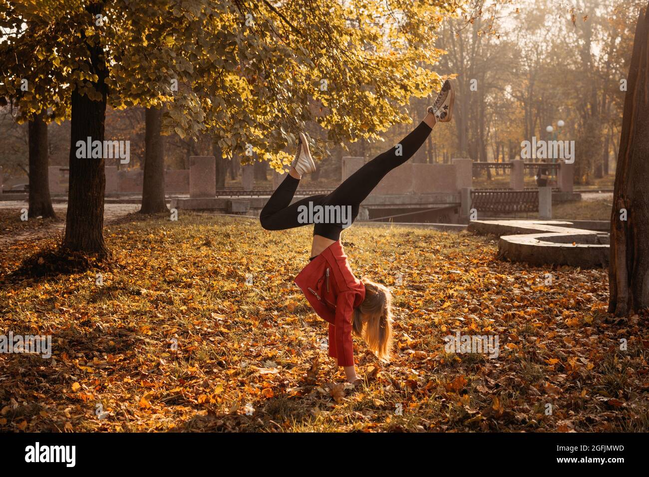 Hallo Herbst, Herbstsaison, Herbststimmung, positive Emotionen. Teenager Mädchen springen mit transparenten Regenschirm und genießen das Leben im Herbst sonnigen Park Stockfoto