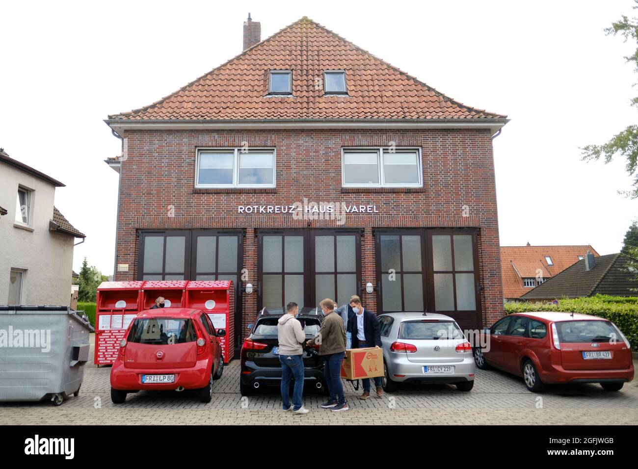 Varel, Deutschland. August 2021. Zivile Polizisten tragen Kisten in ein ziviles Polizeifahrzeug vor dem DRK-Gebäude. In den Morgenstunden durchsuchten Beamte mehrere Gebäude des Deutschen Roten Kreuzes (DRK) in Friesland. Der Soko 'Vakzin' fand während seiner Ermittlungen weitere Unregelmäßigkeiten. (To dpa 'Suchvorgänge während der Untersuchung von Kochsalzeinspritzungen') Quelle: Markus Hibbeler/dpa/Alamy Live News Stockfoto