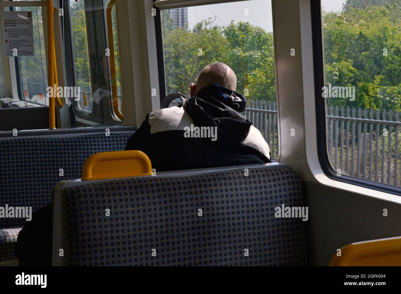 Newcastle. Tyne und Wear. England. 05-27-21. Passagiere, die aus einem Fenster auf einen der S-Bahn-Züge der Stadt blicken. Stockfoto