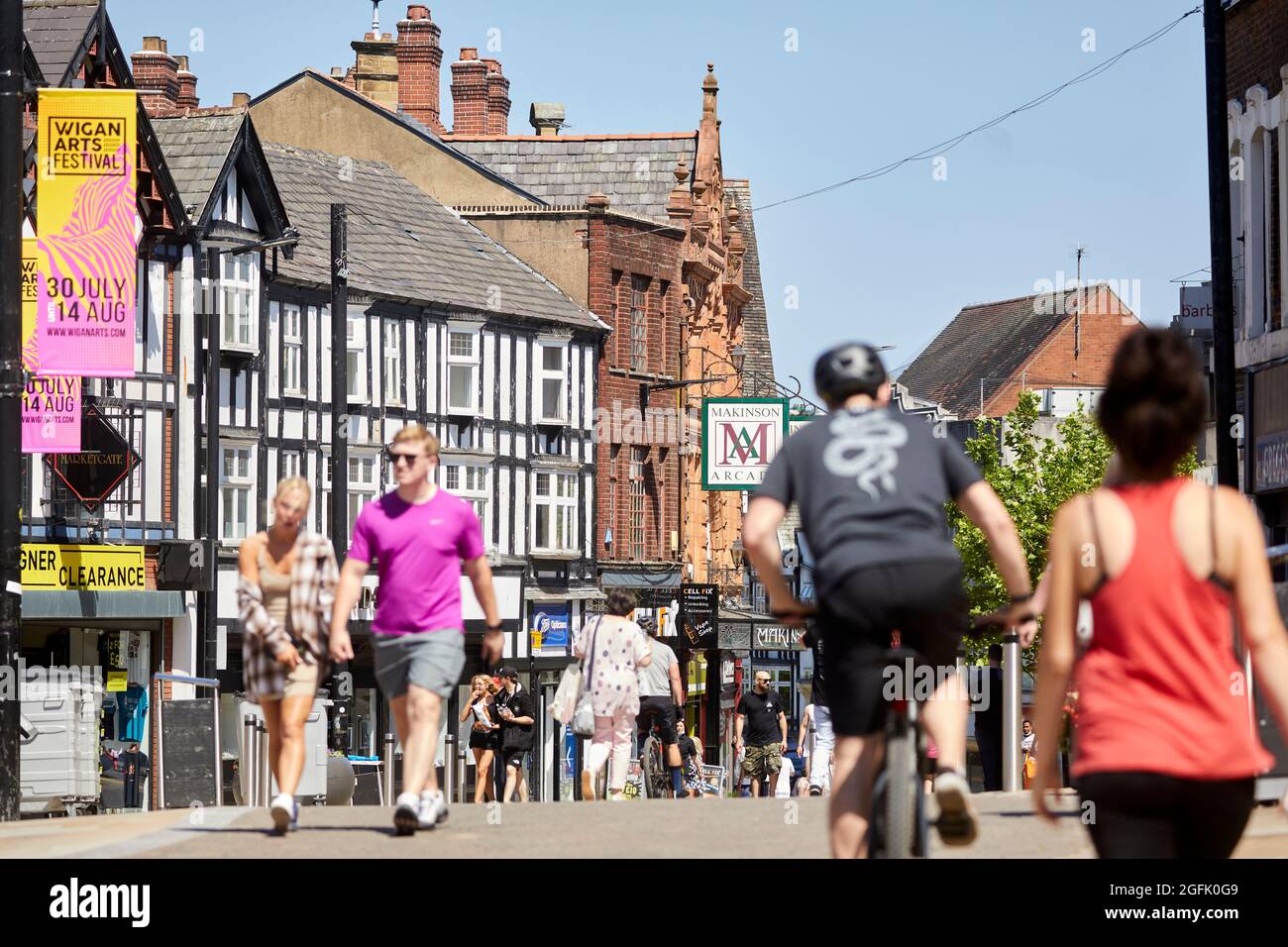 Das Stadtzentrum von Wigan, Lancashire, Geschäfte und Einkaufsmöglichkeiten entlang der Fußgängerzone Market Place und Standischgate Stockfoto