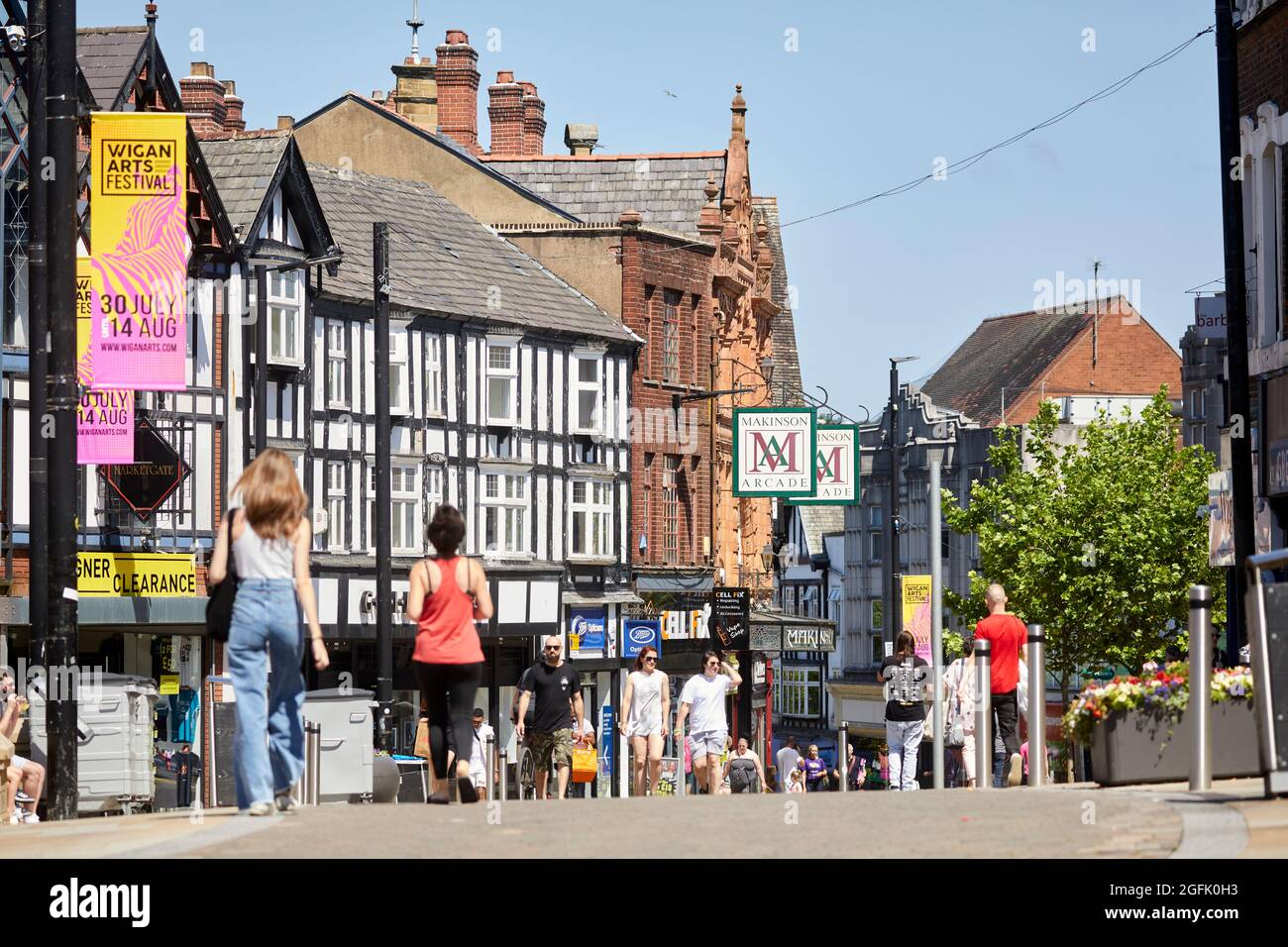 Das Stadtzentrum von Wigan, Lancashire, Geschäfte und Einkaufsmöglichkeiten entlang der Fußgängerzone Market Place und Standischgate Stockfoto