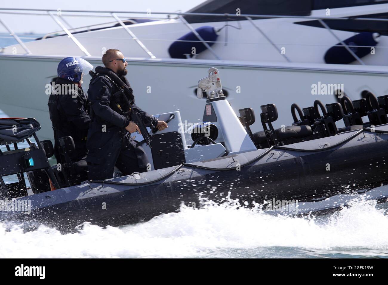 Bewaffnete Polizei in Rippen, die Sportboote nach dem Verlassen des Hafens von Portsmouth durch die HMS Prince of Wales austreiben 22. August 2021 Stockfoto