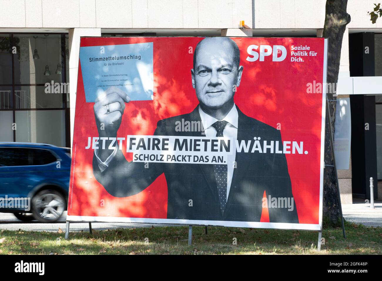 Wiesbaden, Deutschland - 25. August 2021: Wahlkampfplakat der SPD in der Innenstadt von Wiesbaden, Hessen. Die Sozialdemokratische Partei (SPD) ist eine sozialdemokratische politische Partei in Deutschland. Deutschland steht am 26. September vor Bundestagswahlen. Einige Verkehrsteilnehmer im Hintergrund Stockfoto