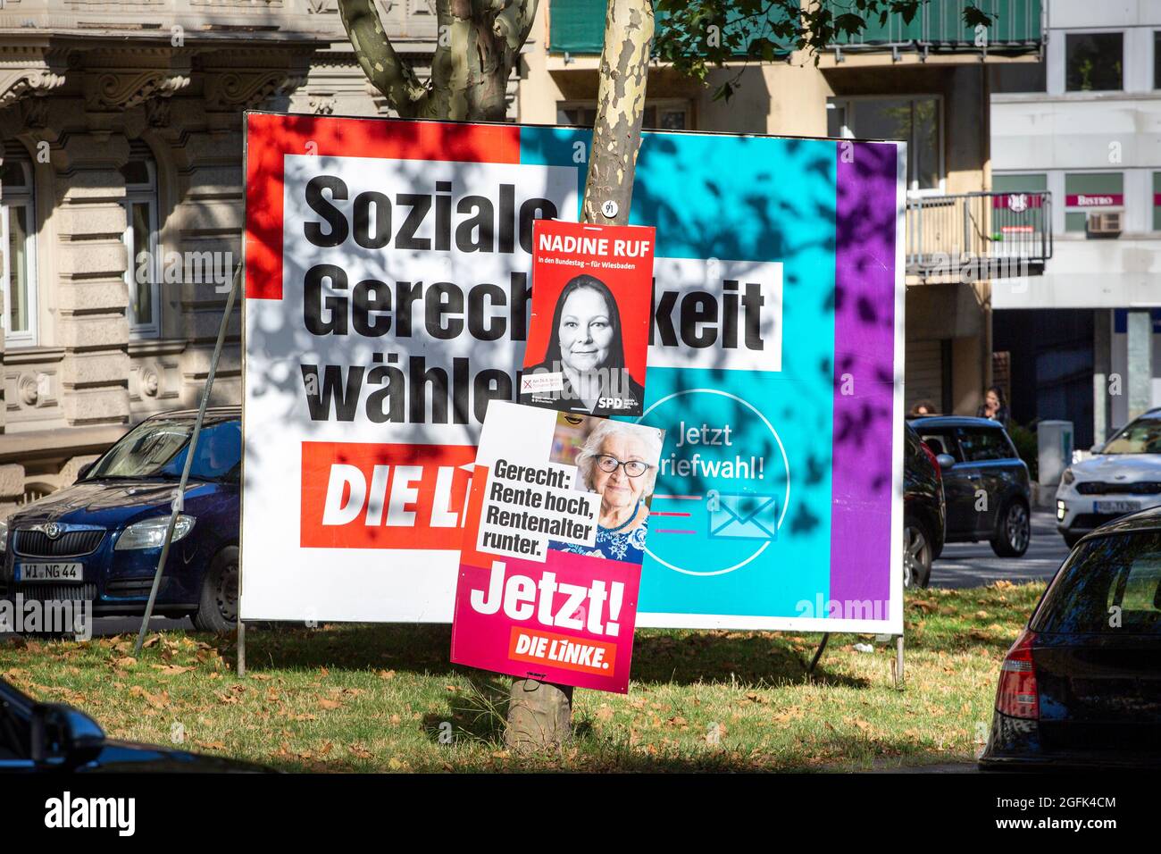 Wiesbaden, 25. August 2021: Wahlkampfplakate der Partei DIE linke und der Sozialdemokratischen Partei (SPD) im Stadtzentrum von Wiesbaden, Hessen. Deutschland steht am 26. September vor Bundestagswahlen. Einige Verkehrsteilnehmer im Hintergrund Stockfoto