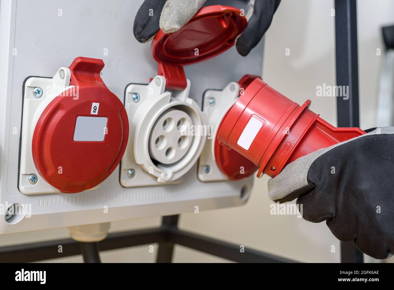 Industriesteckdosen und Stecker auf der Verteilerplatine. Baustelle Strom, temporäre Energieversorgung Stockfoto