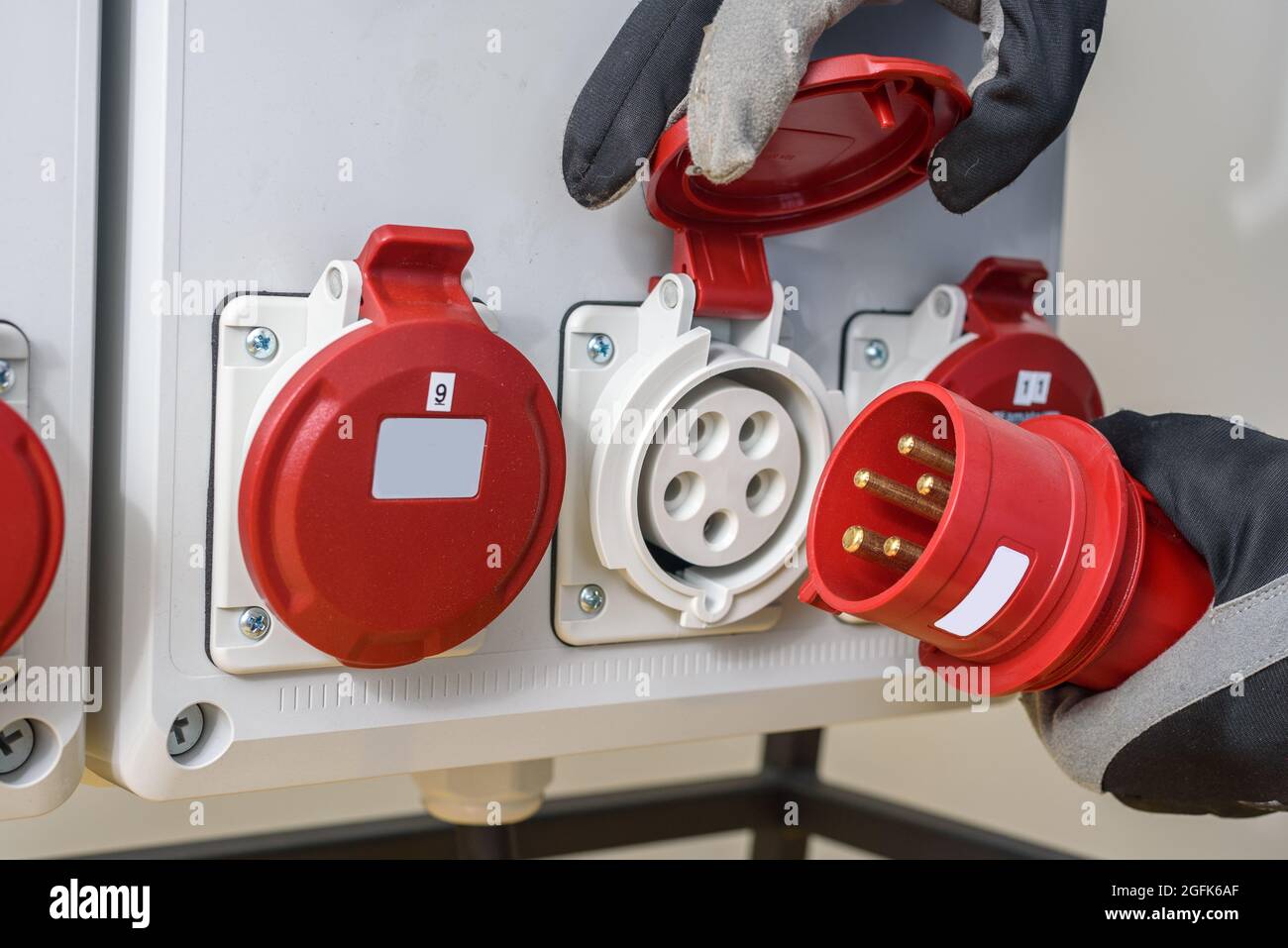 Industriesteckdosen und Stecker auf der Verteilerplatine. Baustelle Strom, temporäre Energieversorgung Stockfoto