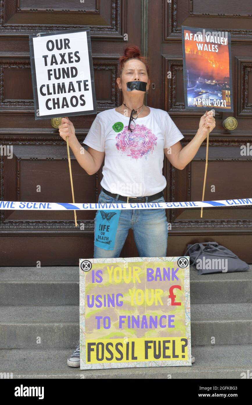 Ein Protestor, der während der Demonstration Plakate vor dem HM Revenue and Customs in Whitehall hält. Stockfoto