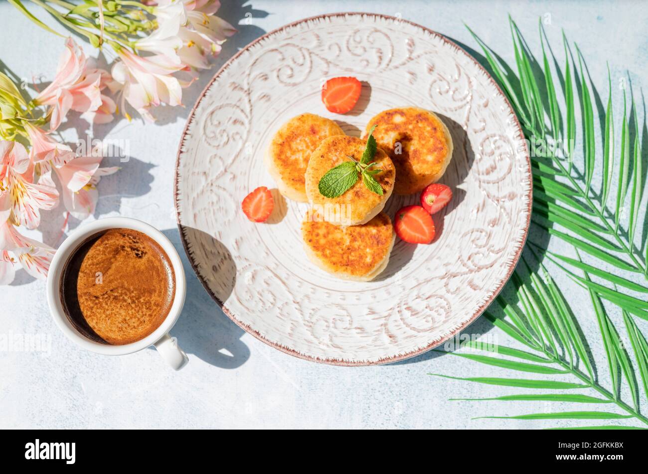 Morgens Frühstück mit Käsepfannkuchen und einer Tasse Kaffee mit Sonnenlicht im Restaurant Stockfoto
