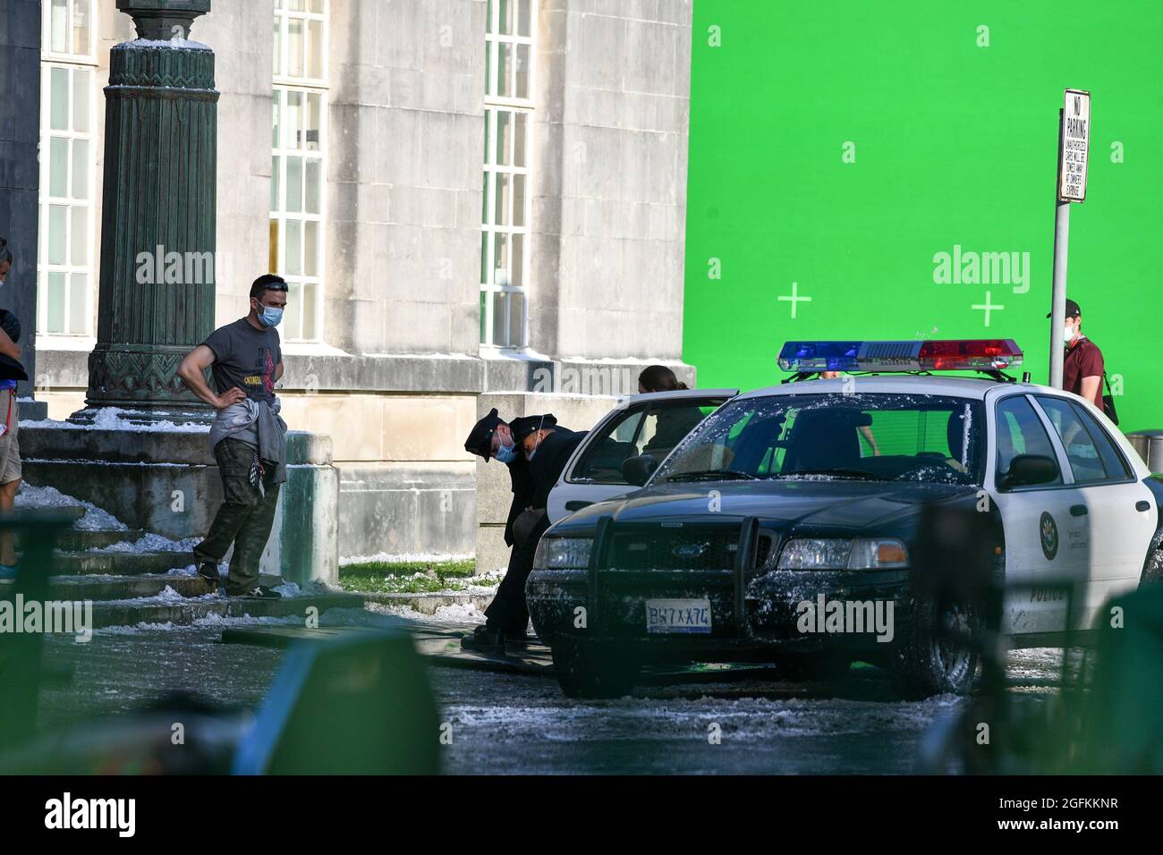 Eine Szene, in der ein Mann aus einem amerikanischen Polizeiauto gezogen wird, wird während der Dreharbeiten zum Netflix-Film Havoc mit Tom Hardy in Swansea eingeprobt. Stockfoto