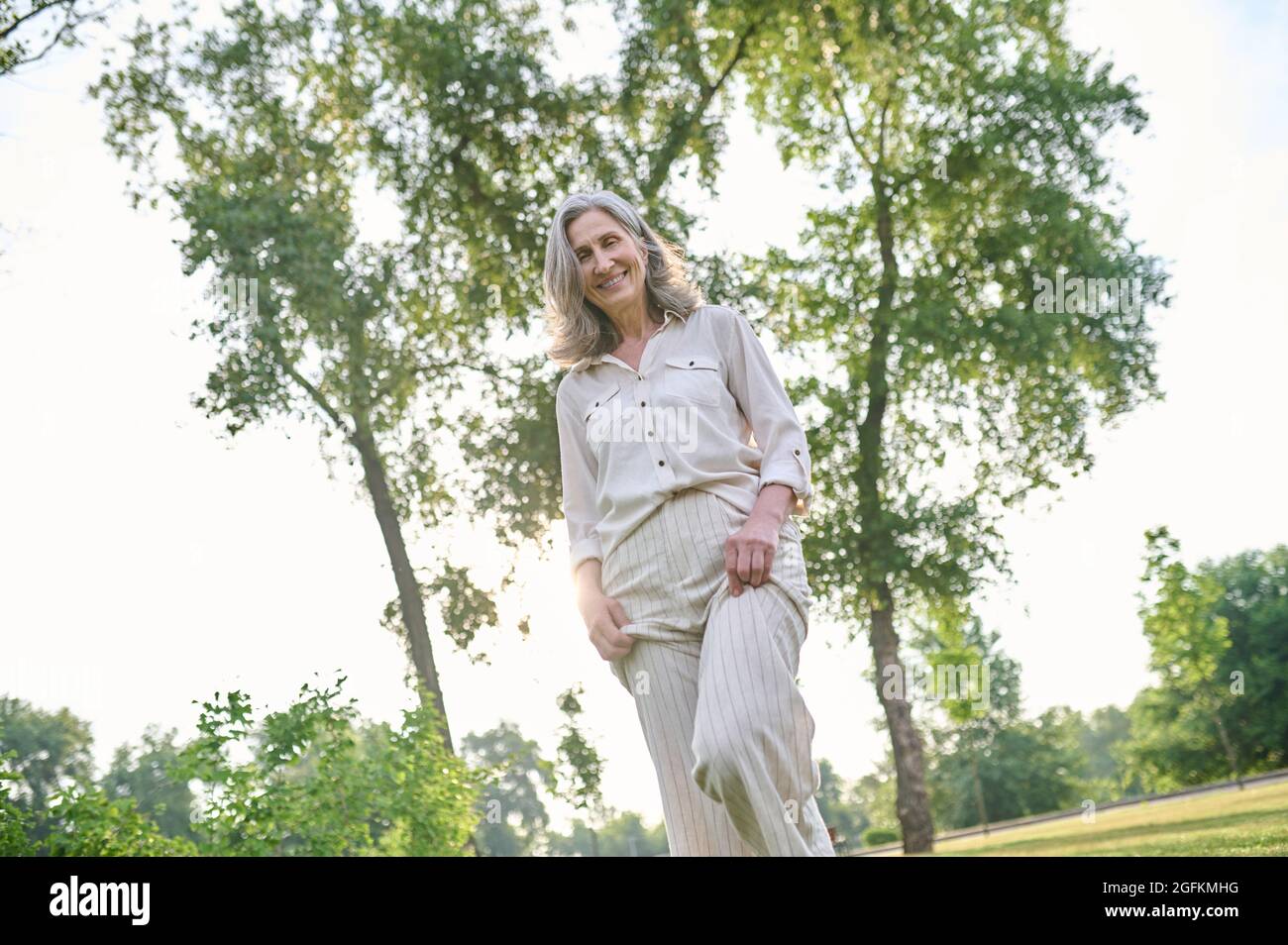 Glückliche Frau, die Freizeit im grünen Park verbringt Stockfoto