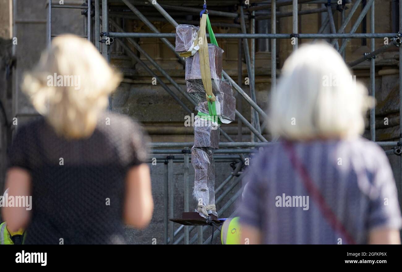 Die Peolple sehen an, wie Antony Gormleys Skulptur „Doubt“ auf ein Gerüst gehoben wird, bevor sie an der Westfront der Wells Cathedral, Wells, Somerset, installiert wird. Bilddatum: Donnerstag, 26. August 2021. Stockfoto