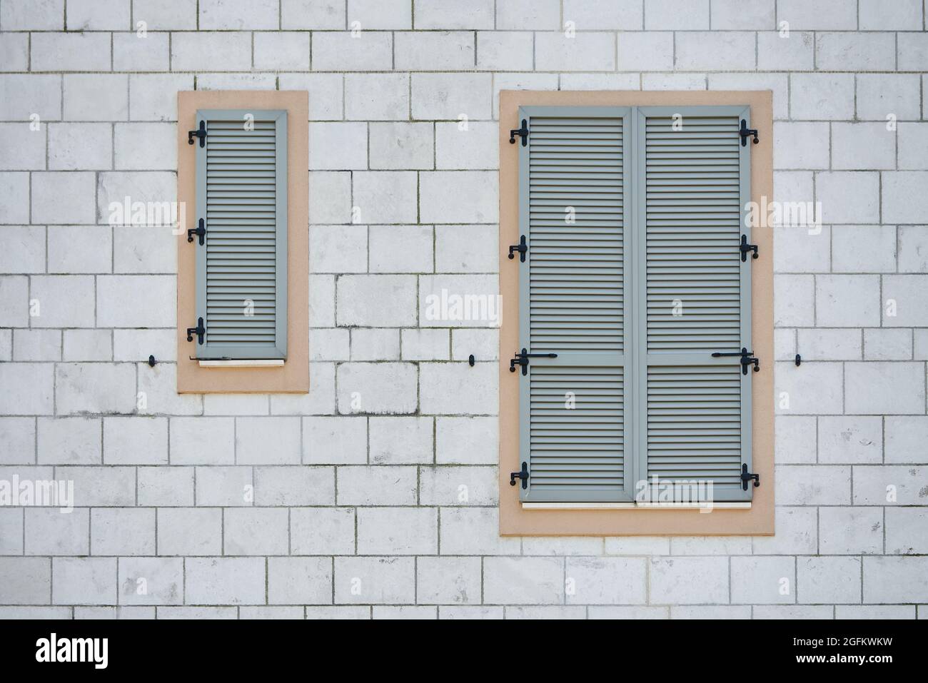 Moderne graue Kunststoff-Fensterläden an der Ziegelwand Stockfoto