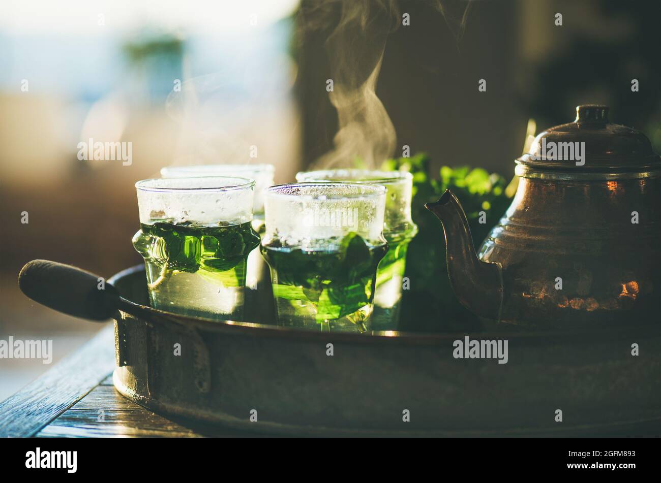 Frischer Minztee in Gläsern und Teekannen im Tablett Stockfoto