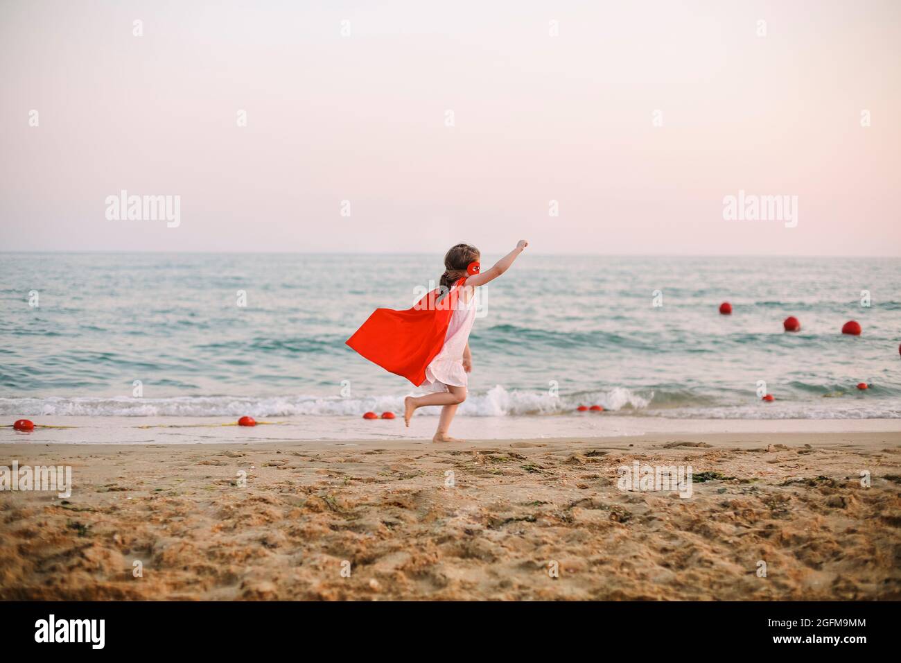 Porträt von Superhero Kind vor blauem Meer Hintergrund. Freude und Kindheit Konzept Stockfoto