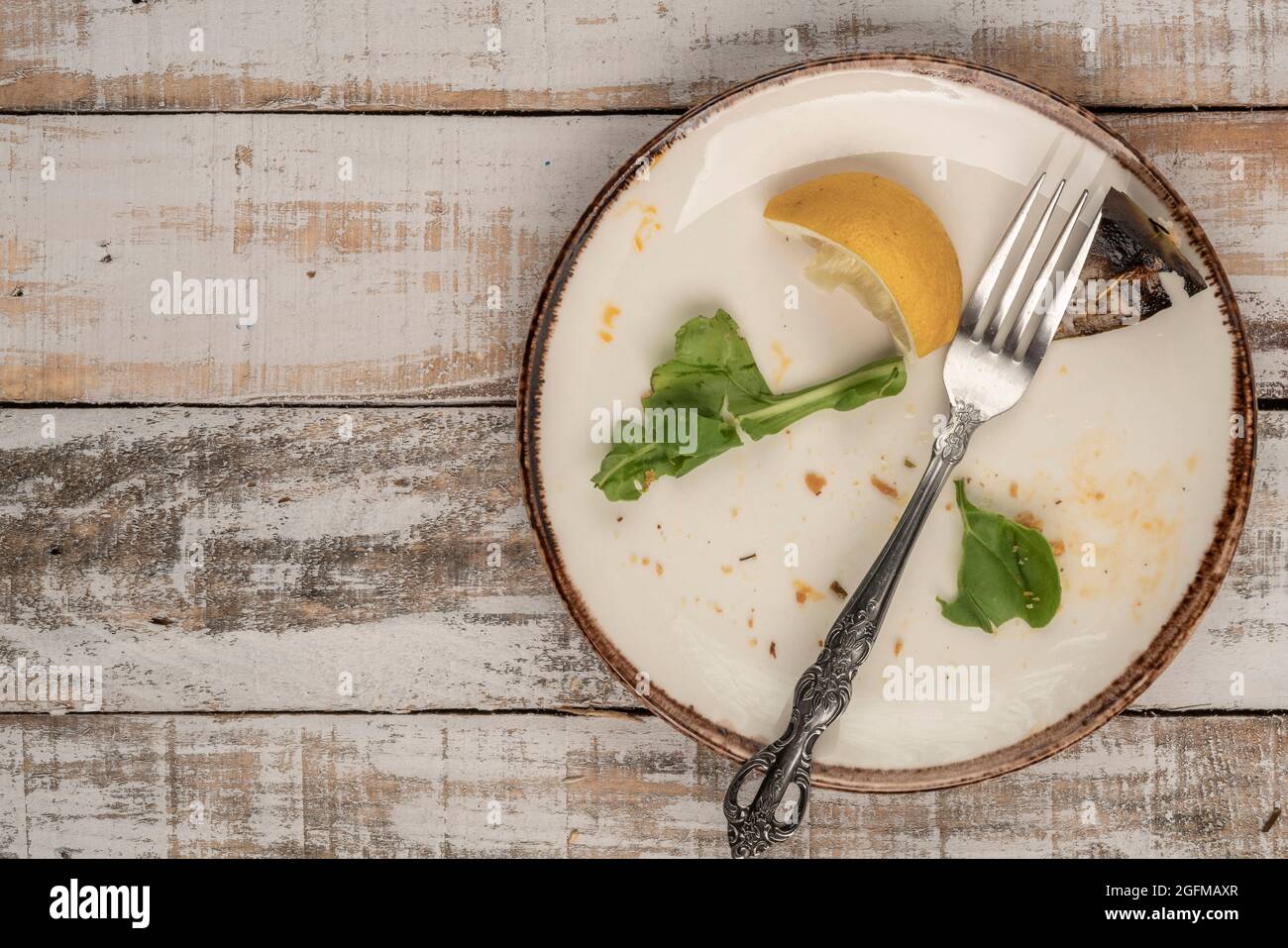 Reste eines Salats auf einem Holztisch Stockfoto