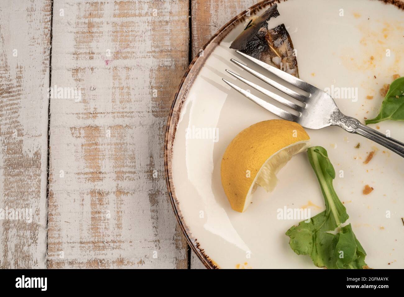 Reste eines Salats auf einem Holztisch Stockfoto