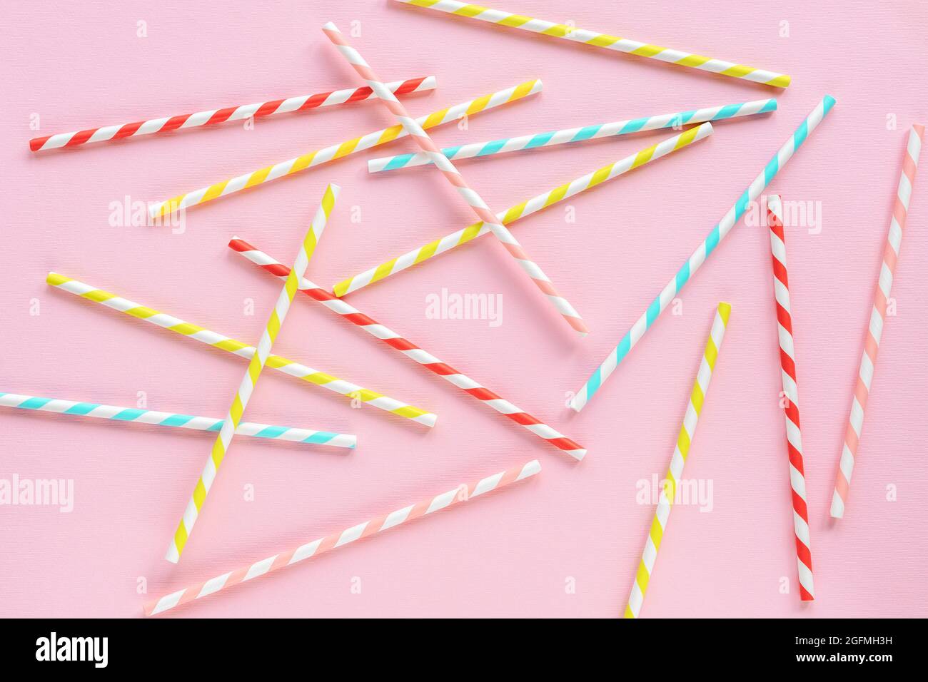 Trinkhalme für Party auf rosa Hintergrund. Draufsicht auf bunte Papier Einweg-umweltfreundliche Trinkhalme für Cocktails. Flach liegend. Stockfoto