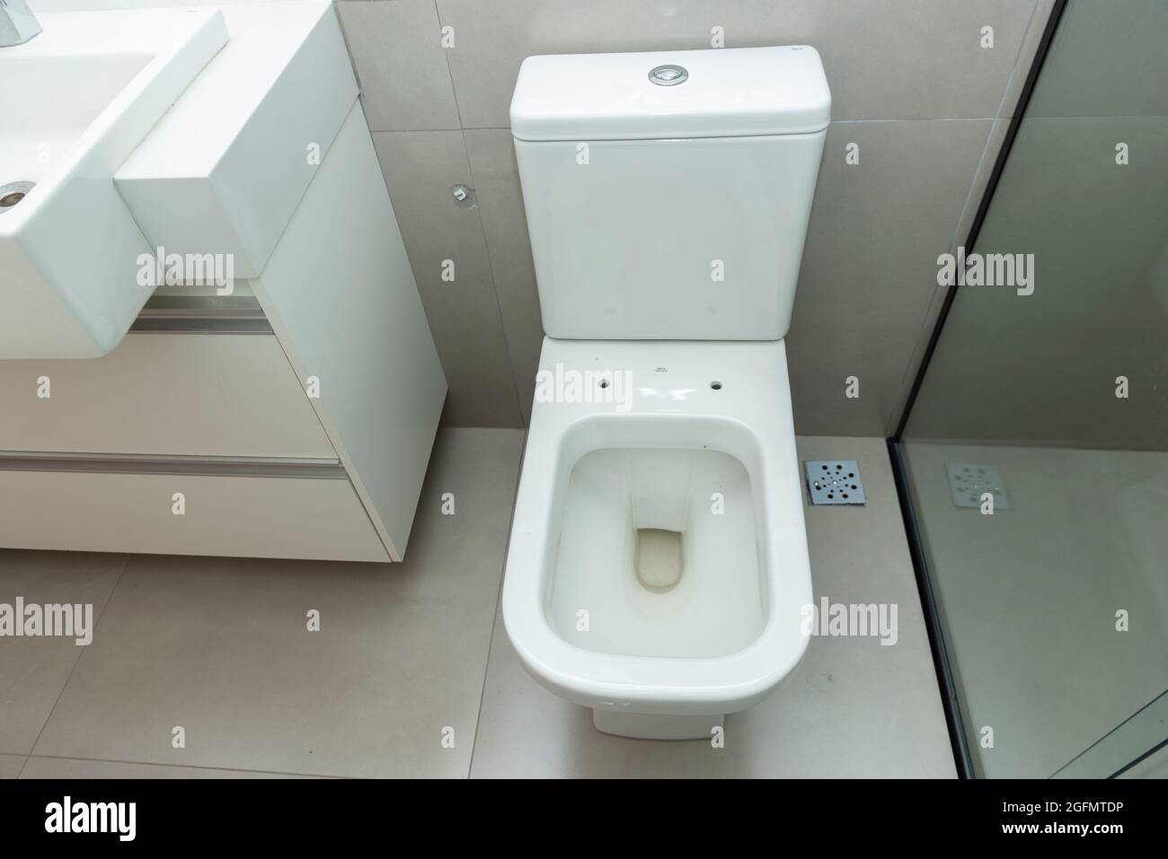 Blick von oben auf die saubere weiße Toilettenschüssel in einem modernen  Badezimmer. Toilette ohne Deckel, um zwischen dem Waschbecken und der  Dusche zu sitzen Stockfotografie - Alamy