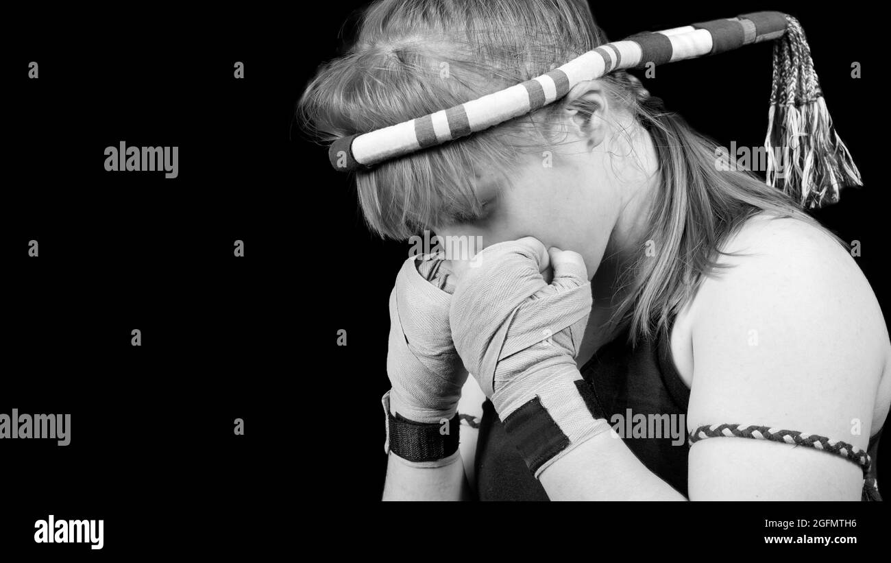 Muay Thai Kämpferin Vorbereitung auf den Kampf. Schwarz-Weiß-Porträt vor schwarzem Hintergrund. Copyspace. Stockfoto