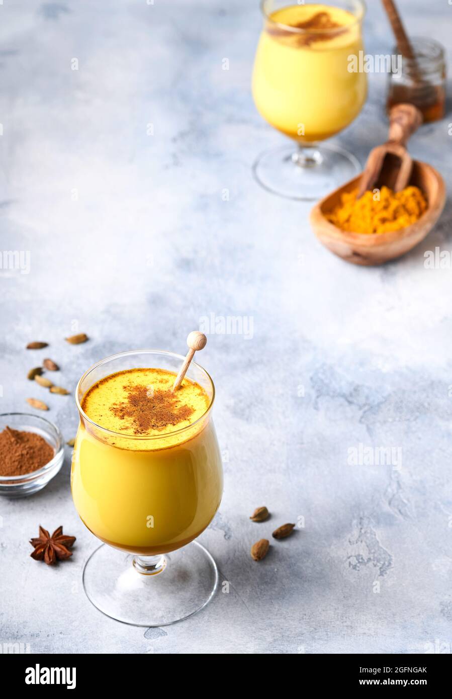 Kurkuma-Latte aus goldener Milch mit Zimtstangen und Honig. Gesundes ayurvedisches Getränk. Trendiges asiatisches natürliches Detox-Getränk mit Gewürzen für Veganer. Kopie en Stockfoto