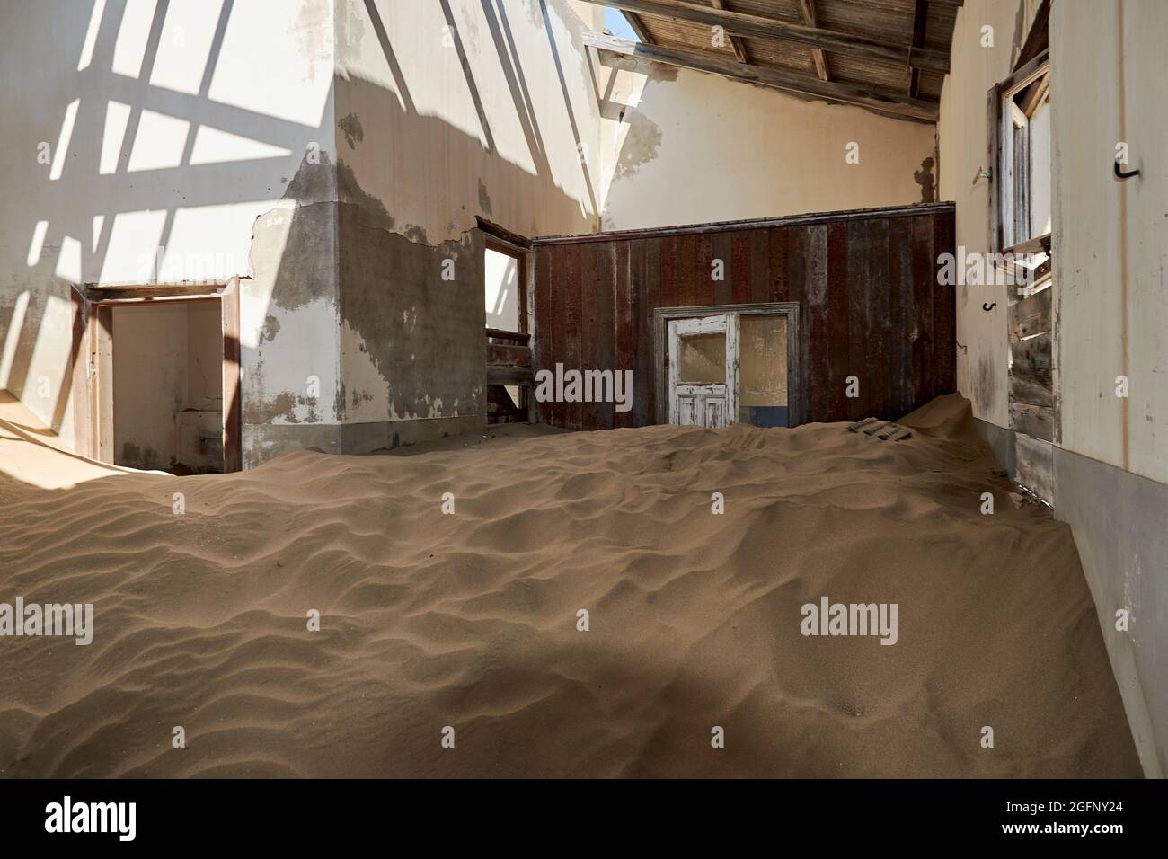 Die Natur hat in einem verlassenen Haus in Kolmanskop, Namibia, Zimmer mit Wüstensand zurückgewonnen. Stockfoto