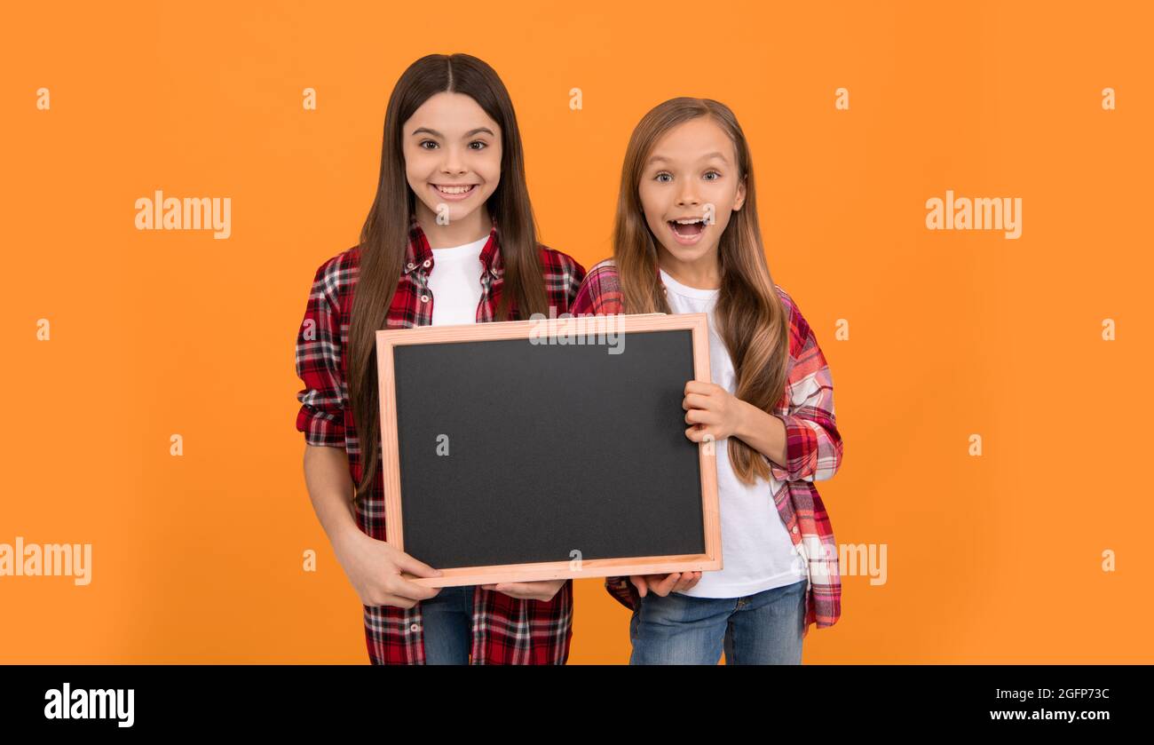 Happy teen Mädchen halten Tafel. Kinder Werbung. Zurück zur Schule. Kinder präsentieren Informationen Stockfoto