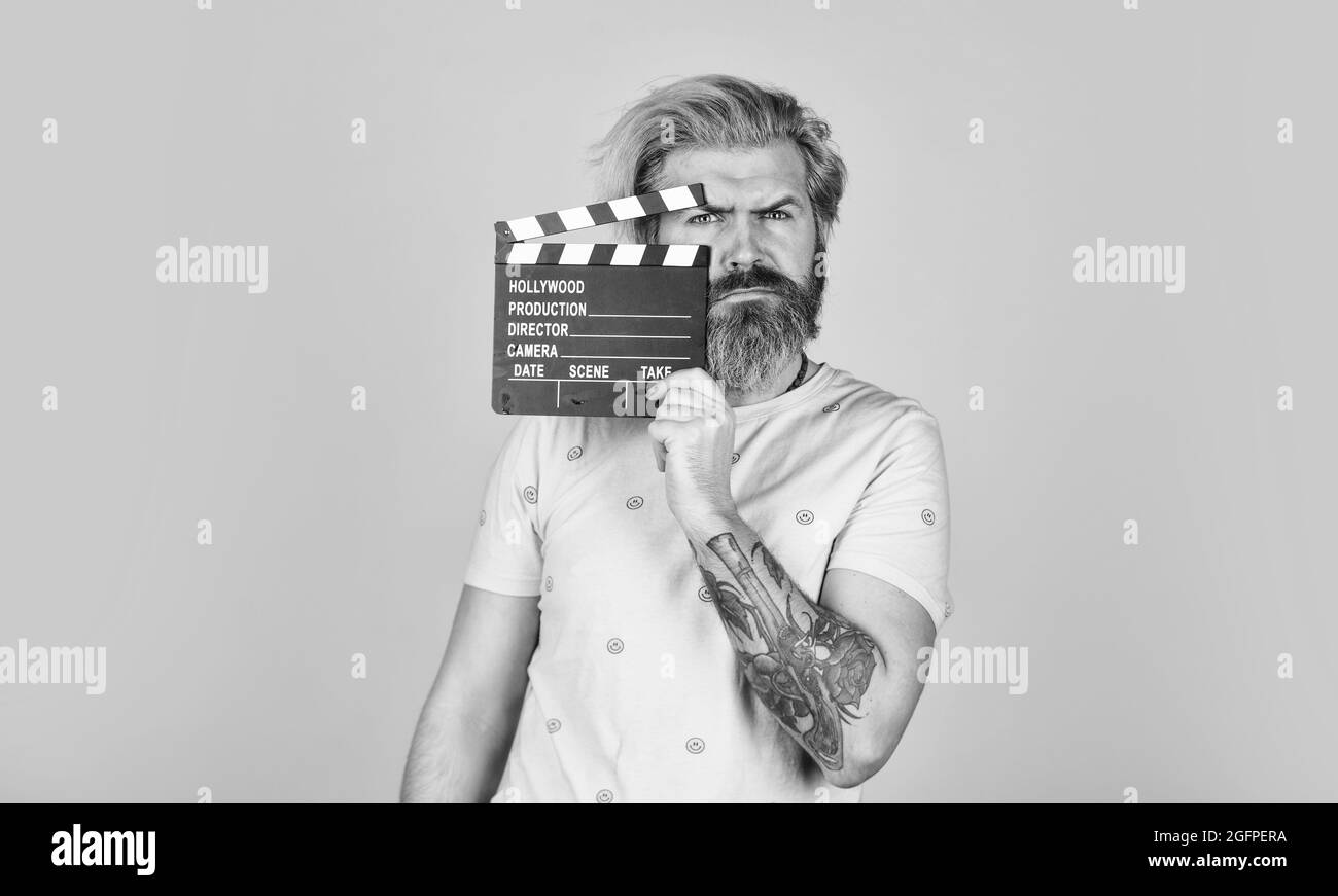 Lieblingsserie. Aktion. Kinoproduktion. Kreativer Produzent. Bärtiger Mann hält Filmklapper. Filmkonzept. Klapperboard-Kopierraum. Sehen Sie Stockfoto