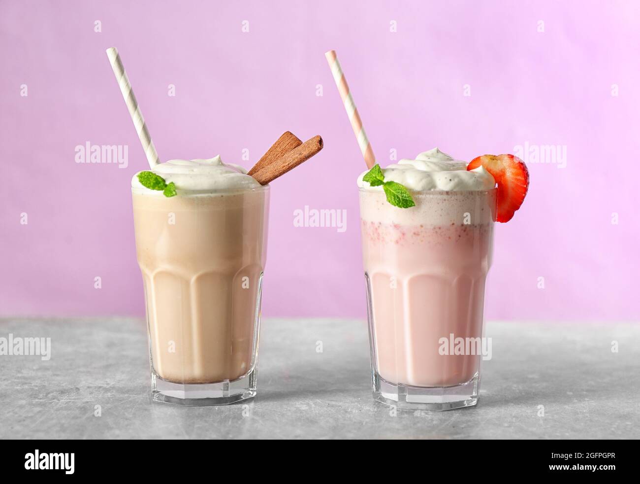 Gläser von leckeren Milchshake auf rosa Hintergrund Stockfotografie - Alamy