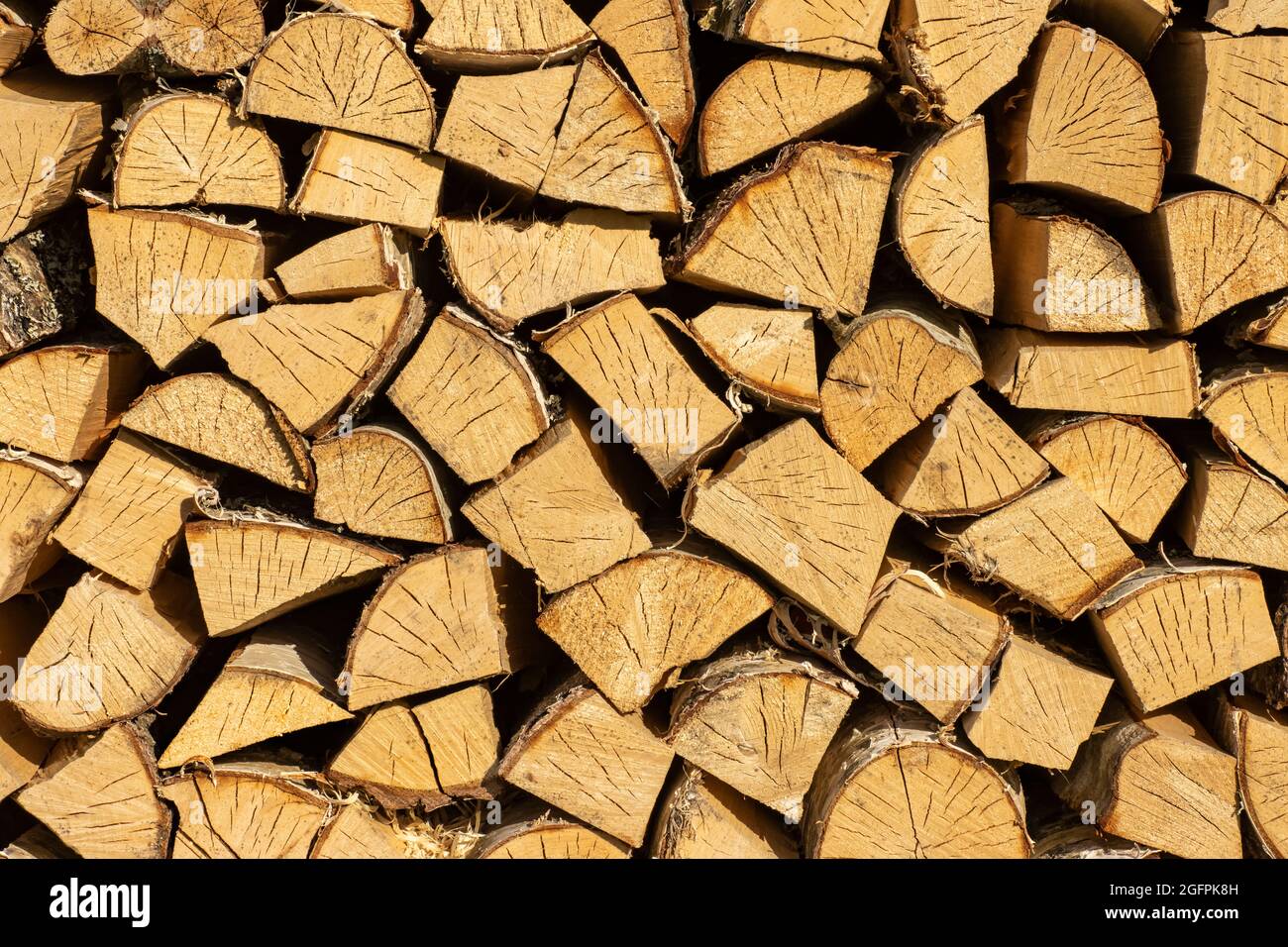 Gestapelter Holzstapel aus Brennholz, strukturierter Holzhintergrund für Design. Stockfoto