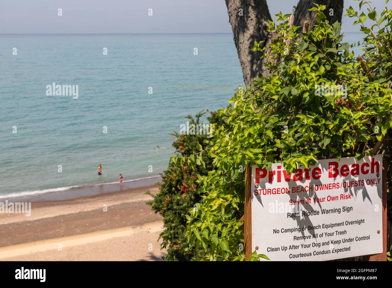 New Buffalo, Michigan - EIN Schild warnt davor, dass ein Strand am Lake Michigan privat ist. Obwohl der Strand in Privatbesitz sein kann, hat die Öffentlichkeit das Recht darauf Stockfoto
